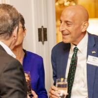 Mike Ellis speaking with another two guests at the party